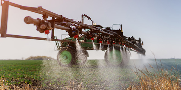 A photo of a sprayer spraying herbicides on soybean field
